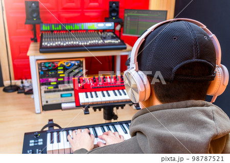 back of asian male music producer, composer recording a song by midi keyboard in home studio. music production concept 98787521