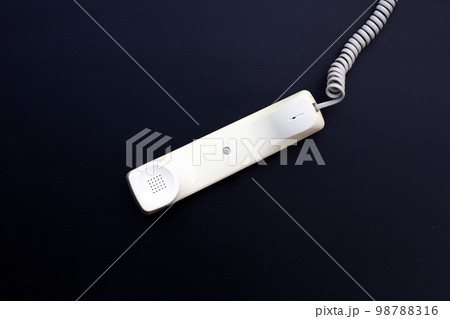 Handset of landline phone on dark background. 98788316