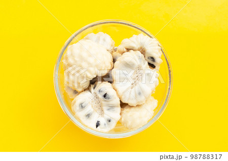Custard apple in glass bowl on yellow background. 98788317
