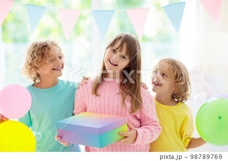 Kids birthday party. Child blowing out cake candle 98789769