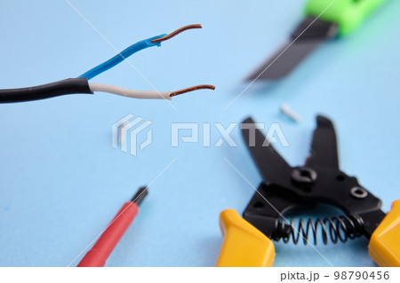 Tools and materials for an electrical project lie on table. 98790456