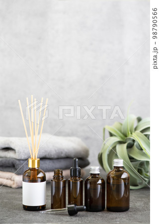 茶色いガラス瓶とアロマディフューザーとタオル 98790566