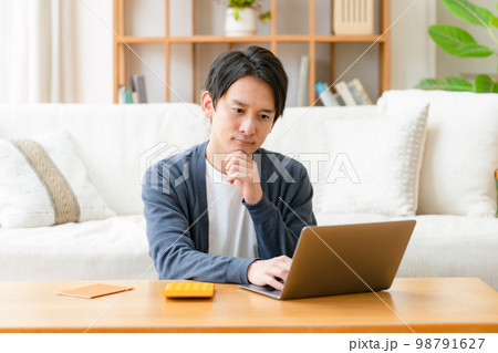 悩む男性　計算機　ライフプラン 98791627