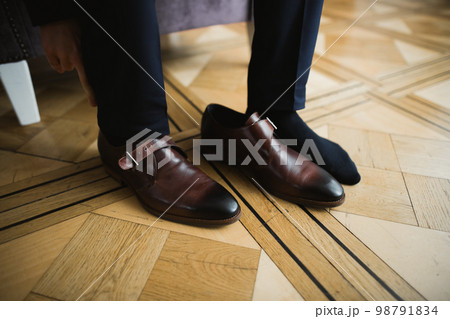 Grooms morning preparation. Handsome man getting dressed and preparing for the wedding Grooms morning preparation. Handsome man getting dressed and preparing for the wedding 98791834
