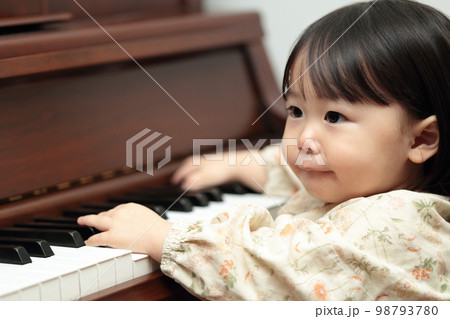 アップライトピアノを弾く1歳の女の子 98793780