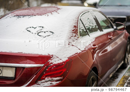 Hearts hand-drawn on car's window on background of snow. Concept of love, romance, Valentine's Day 98794467