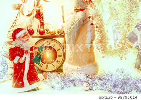 Two Santa Claus and vintage clock in golden silver Christmas New Year lights Two Santa Claus and vintage clock in golden silver Christmas New Year lights 98795014