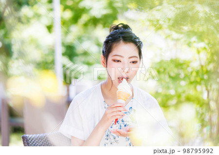 笑顔でソフトクリームを食べる若い女の子 笑顔でソフトクリームを食べる若い女の子 98795992