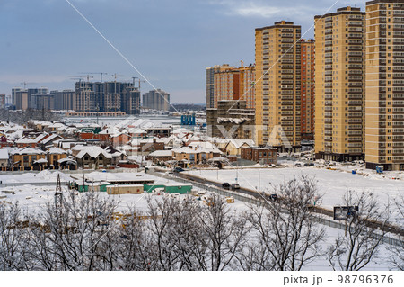 Winter urban landscape. New Residential buildings, snow covered land and privat houses 98796376