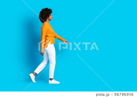 Cool stylish curly black woman walking towards copy space Cool stylish curly black woman walking towards copy space 98796956