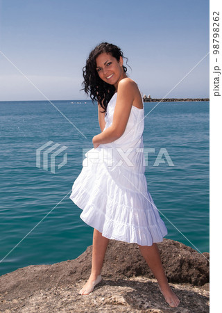 young woman on the beach enjoying the good weather near the sea 98798262