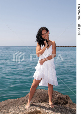 young woman on the beach enjoying the good weather near the sea young woman on the beach enjoying the good weather near the sea 98798263