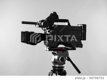 Modern professional video camera on light background Modern professional video camera on light background 98798702
