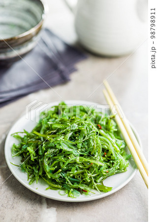 Green seaweed. Japanese wakame salad on plate. 98798911