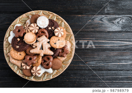 Delicious cookies in plate on black wooden table, top view. Space for text Delicious cookies in plate on black wooden table, top view. Space for text 98798979