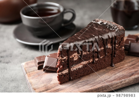 Piece of delicious chocolate cake on grey table Piece of delicious chocolate cake on grey table 98798983