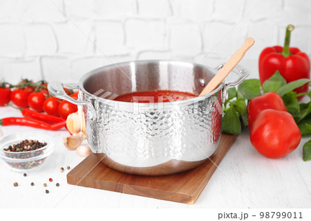 Delicious tomato sauce and fresh ingredients on white wooden table 98799011