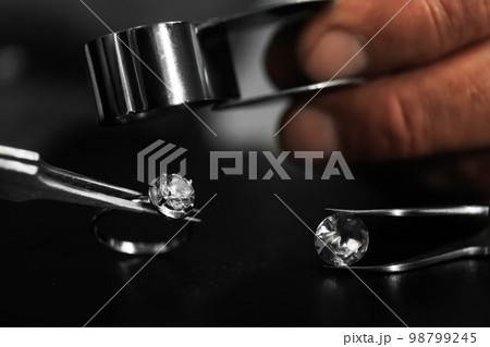 Professional jeweler working with beautiful ring at table, closeup 98799245