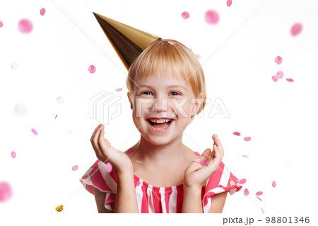 Girl in a bright, festive dress and playful cap Girl in a bright, festive dress and playful cap 98801346