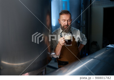 Brewery factory owner examining quality of craft beer 98801782