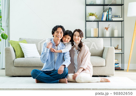 リビングでくつろぐ若い家族 リビングでくつろぐ若い家族 98802650