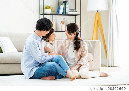 リビングでくつろぐ若い家族 リビングでくつろぐ若い家族 98802660