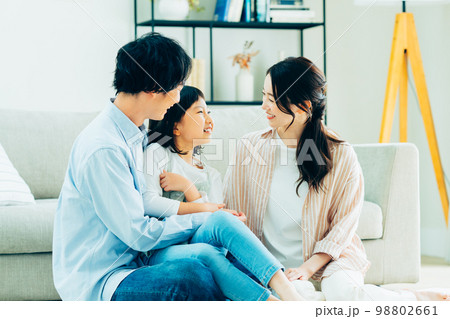 リビングでくつろぐ若い家族 98802661