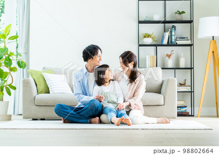 リビングでくつろぐ若い家族 98802664