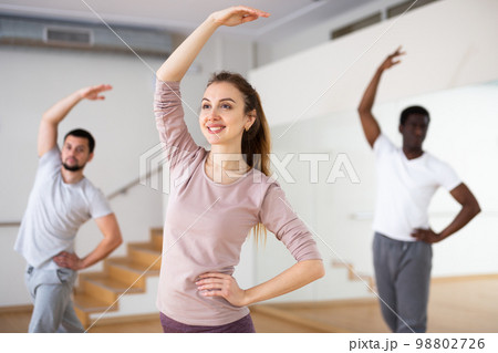 Woman training classical dance moves with group in studio 98802726