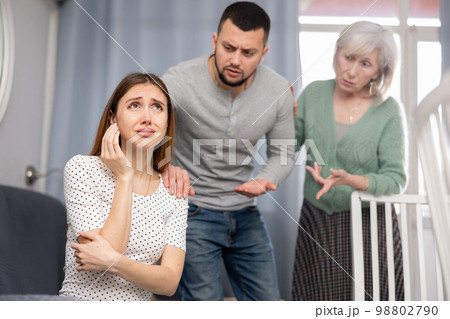 Man and mature woman scolding young woman Man and mature woman scolding young woman 98802790