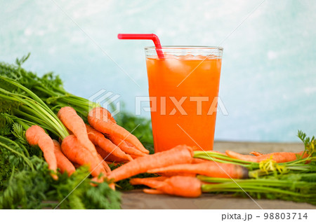 carrot juice on wooden table background, fresh and sweet carrots for cooking food fruits and vegetables for health concept, fresh carrots juice on glass with ice on summer 98803714