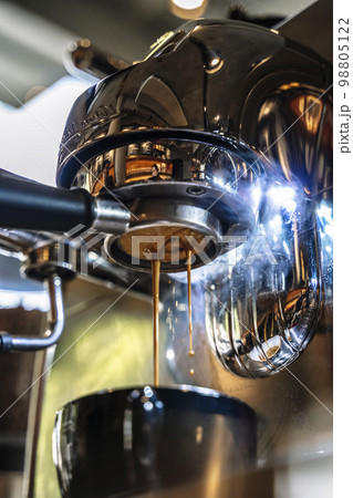 Barista makes coffee in a coffeeshop. Cup of cappuccino or latte in the making. Selected focus 98805122