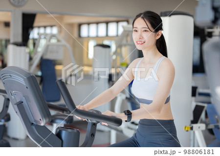 エアロバイクに乗る若い女性 エアロバイクに乗る若い女性 98806181