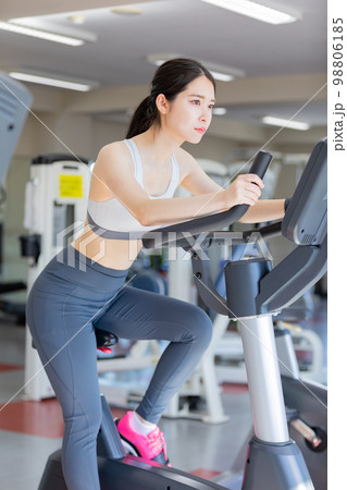 エアロバイクに乗る若い女性 98806185