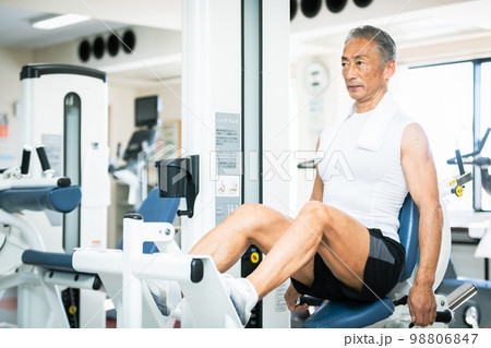 ジムでレッグエクステンションを使って大腿四頭筋を鍛えるシニア男性 ジムでレッグエクステンションを使って大腿四頭筋を鍛えるシニア男性 98806847