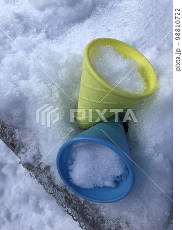 おもちゃのアイスのコーンのカップに雪が入っている写真 98810722
