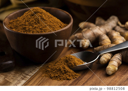 木のテーブルに秋ウコンの根茎とターメリックパウダー 98812508
