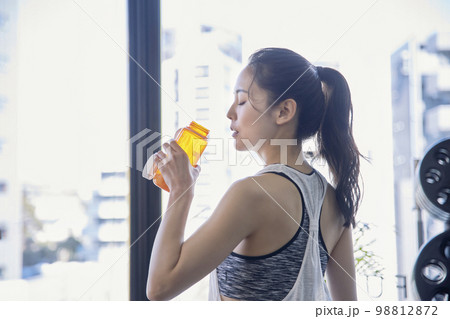 ジムで水分補給する若い女性 ジムで水分補給する若い女性 98812872