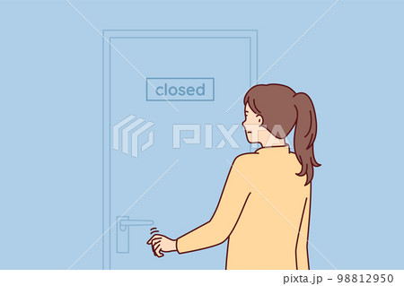 Indecisive woman pulls hand to door with inscription closed stands with back to screen Indecisive woman pulls hand to door with inscription closed stands with back to screen 98812950