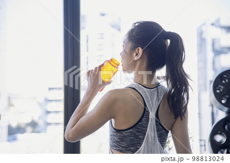 ジムで水分補給する若い女性 ジムで水分補給する若い女性 98813024