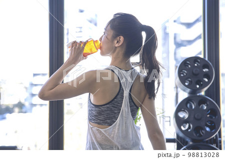 ジムで水分補給する若い女性 98813028