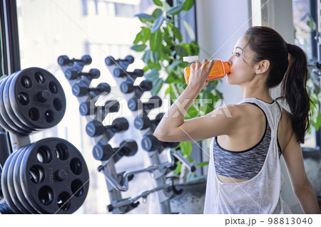 ジムで水分補給する若い女性 98813040