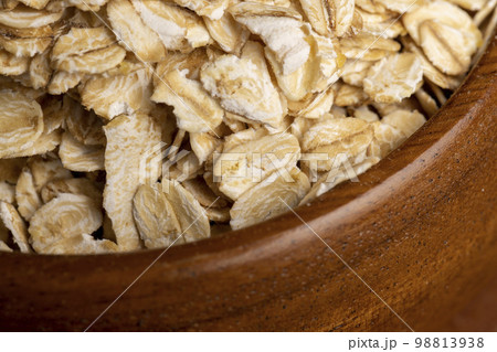 Oat flakes scattered on a wooden surface 98813938