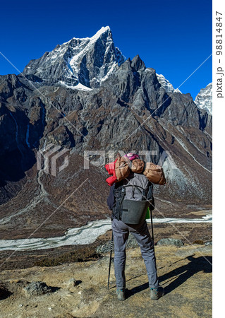 Hiker woman posing with mountains at background Hiker woman posing with mountains at background 98814847