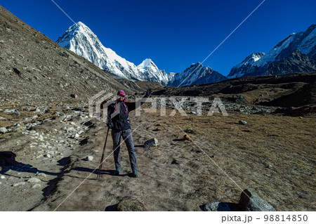 Hiker woman posing with mountains at background Hiker woman posing with mountains at background 98814850