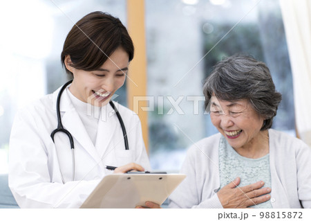シニア女性を診察する女性医師　往診　訪問診療 98815872