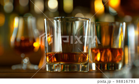 Close-up of pouring whiskey or rum on the bar, dark toned background 98816793