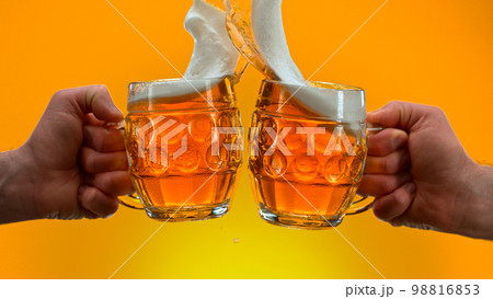 Freeze motion of beer glasses in cheers gesture, close-up Freeze motion of beer glasses in cheers gesture, close-up 98816853