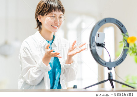 開放的な部屋で動画配信をする若い女性 98816881