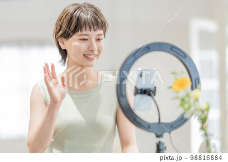 動画配信にフォロワーに手を振る若い女性 動画配信にフォロワーに手を振る若い女性 98816884